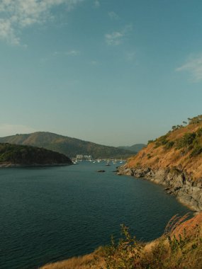 Kayalık bir kıyı şeridi olan güzel mavi bir okyanus. Su sakin ve gökyüzü berrak.