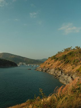Kayalık bir kıyı şeridi olan güzel bir okyanus manzarası. Su sakin ve gökyüzü berrak.