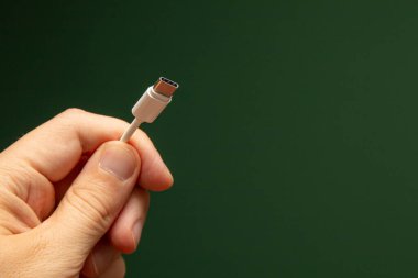 usb-c kablosunu tutan eli kapat