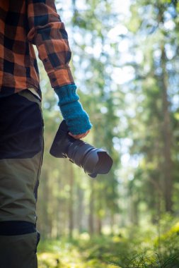 Doğa fotoğrafçılığı. Ormanda profesyonel bir kamerayla el ele tutuşuyoruz..
