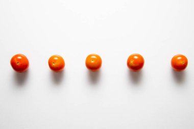 Beyaz arka planda üst üste dizilmiş kiraz domateslerinin üst görüntüsü