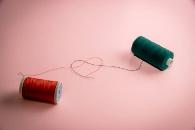 İplikten kalp şekli oluşturan iplik ruloları dikiyorum. Dikiş konsepti.