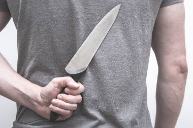 Arkasından mutfak bıçağı tutan bir adam..