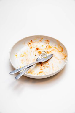 Çatal ve bıçaklı kirli bir tabak.