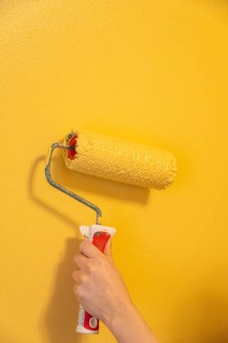 Patenli Fırça Boyama. Yüzey duvarındaki işçi boyası daire boyası, sarı renkte boya..