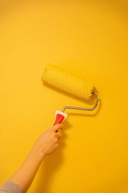 Patenli Fırça Boyama. Yüzey duvarındaki işçi boyası daire boyası, sarı renkte boya..