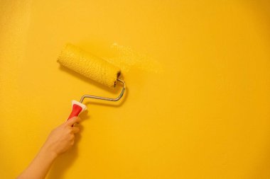 Patenli Fırça Boyama. Yüzey duvarındaki işçi boyası daire boyası, sarı renkte boya..