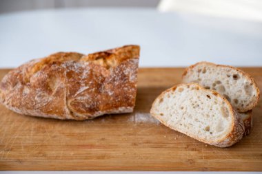 Tahta kesme tahtasının üzerinde taze pişmiş ekmek.