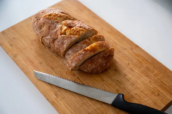 Tahta kesme tahtasının üzerinde taze pişmiş ekmek.