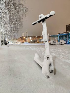 Kar fırtınasından sonra karla kaplı elektrikli scooter