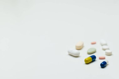 Beyaz arka planda renkli haplar ve kapsüller