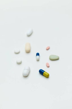 Beyaz arka planda renkli haplar ve kapsüller