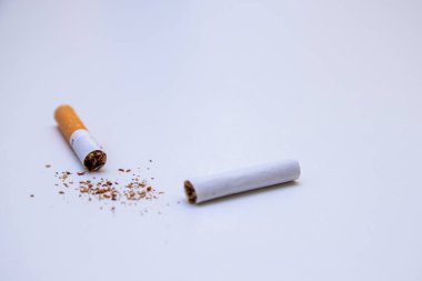 Beyaz arka planda ikiye bölünmüş bir sigara