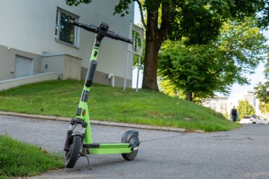 Kaldırıma park etmiş yeşil elektrikli scooter.