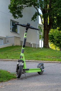 Parlak Yeşil Elektrikli Scooter Güneşli bir günde açık havada park etti