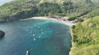 Tekneleri ve beyaz kumlu tropik plajları olan güzel bir koy. Crystal Bay Nusa Pineda Endonezya. Hava aracı görüntüsü 4K. DJI Mavic 3 