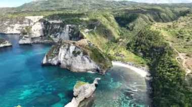 Tropikal sahil ve denizin kuş bakışı görüntüsü. Kıyı kayalıklarının muhteşem manzarası. Atuh Beach Nusa Penida Endonezya Bali. 4K insansız hava aracı görüntüleri dji Mavic 3