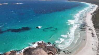 Hava aracı elektrikli mavi suyu görüntüler. Denizde büyük granit kayalar. Twilight Beach Esperance Avustralya. 4K Mavic 3 