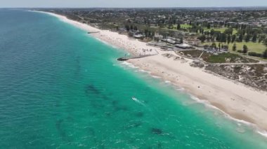 City Beach Perth Avustralya 'nın destansı hava manzarası. Yazın güneşlenen ve denizde yüzen bir sürü insan var. Batı Avustralya kıyı şeridi, insanlar tatilde. Hava aracı görüntüsü 4K. DJI Mavic 3