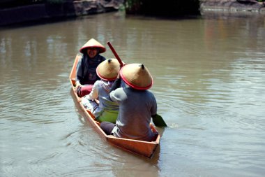Tuntang, Semarang, Central Java, Endonezya - 29 Aralık 2019: Kampoeng Banyumili 'deki tropik bahçenin ortasında yapay göl üzerinde ahşap bir tekneye binmek