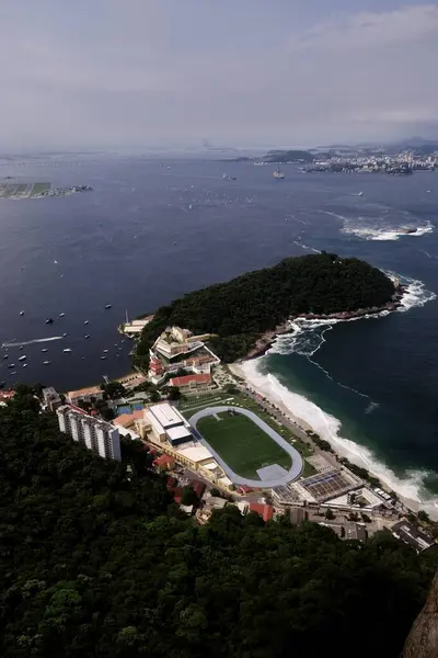 stock image An aerial view of a sports complex nestled along Rio de Janeiro's coastline, surrounded by lush greenery and the Atlantic Ocean. Perfect for urban planning, travel, and sports-related content