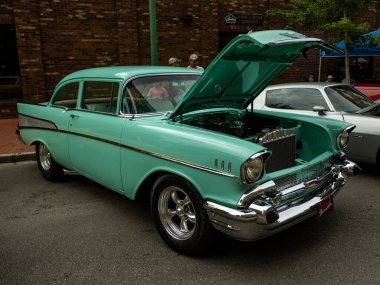 Klasik yeşil Chevrolet Bel Air, klasik tasarımı ve Chevy Thunder mirasını sergileyerek tuğla bir duvara yaslandı..