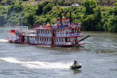 Nehir teknesi ve jet ski canlı bir sahne yaratıyor, su sporlarının heyecanını gözler önüne seriyor..