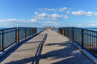 Anna Maria Adası Florida 'daki Holmes Sahili' nde güneşli bir günde okyanusa açılan uzun bir iskele.