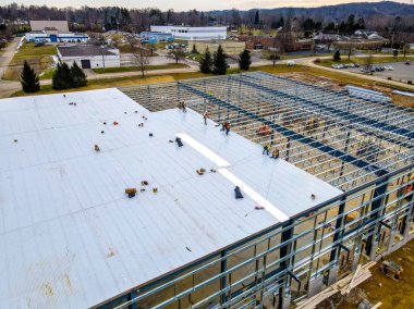 İnşaat işçilerinin inşaat sahasına yeni bir çatı kurma görüntüsü..