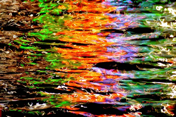 The rhythm of brown, green, orange, purple colors in the water at night...