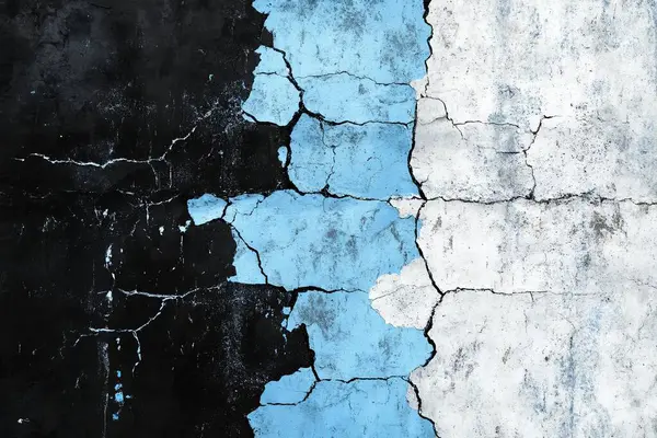 stock image Close-up of a weathered wall with peeling black, blue, and white paint in a cracked texture.