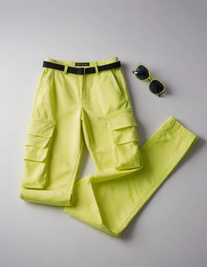 Vibrant yellow cargo pants with matching sunglasses, perfect for a bold summer look. clipart