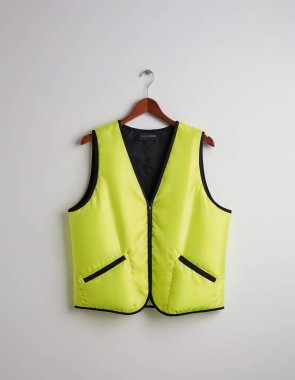 A vibrant yellow safety vest hanging neatly, designed for visibility and protection. clipart