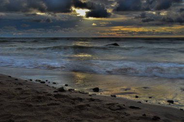 Baltık deniz kıyıları, güzel bir gün batımı ve dramatik bulutlar.