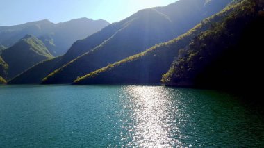 ALBANIA.Lake Koman, Arnavutluk 'un kuzeyindeki Drin Nehri' nde, sık ormanlık tepeler, dikey yamaçlar, derin vadiler ve dar bir vadiyle çevrili bir rezervuar.