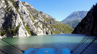 ALBANIA.Lake Koman, Arnavutluk 'un kuzeyindeki Drin Nehri' nde, sık ormanlık tepeler, dikey yamaçlar, derin vadiler ve dar bir vadiyle çevrili bir rezervuar.