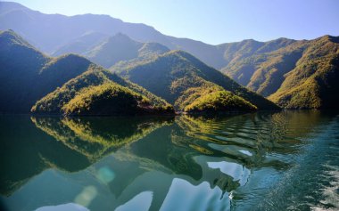 ALBANIA.Lake Koman, Arnavutluk 'un kuzeyindeki Drin Nehri' nde, sık ormanlık tepeler, dikey yamaçlar, derin vadiler ve dar bir vadiyle çevrili bir rezervuar.