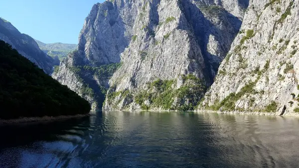 ALBANIA.Lake Koman, Arnavutluk 'un kuzeyindeki Drin Nehri' nde, sık ormanlık tepeler, dikey yamaçlar, derin vadiler ve dar bir vadiyle çevrili bir rezervuar.