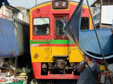 THAILAND MEKLONG Meklong Demiryolu Pazarı, tren geçmek üzereyken, birkaç saniye içinde kendimizi geçişe izin vermek için organize ederiz, ondan sonra her şey bir anda eski haline döner.