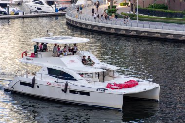 Dubai Marina 'da bir yatta turistlerin yüksek açılı görüntüsü.