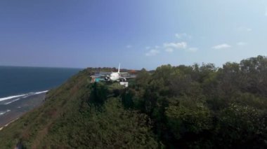 Uçurumun üzerinde bir FPV uçağı uçurmak. Çekimler Bali adasında, tepede yüzme havuzlu, panoramik manzaralı bir uçak şeklinde bir otel var.