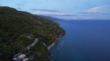 Filipinler 'deki Cebu adasının kıyısında kristal berrak su. Ada boyunca bir İHA 'nın görüntüsü, adanın yol ve ormanını gösteriyor.
