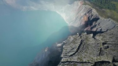 Ijen volkan krateri ve sülfür gölünün destansı manzarası. Volkanik çatlaklar ve volkanın buharları görülebilir. Drone görünümü - Endonezya, Java