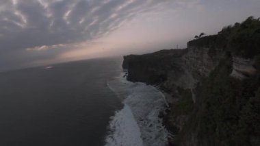 FPV İHA 'sı Bali adasındaki uçurumlar boyunca uçuyor. Dalgalar kayalara çarpıyor..