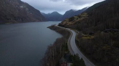 Fiyortlarda bulunan dolambaçlı bir yol, Norveç 'in genişliğinin akşam manzarası: en temiz su, yeşil ormanlar, karla kaplı dağ zirveleri