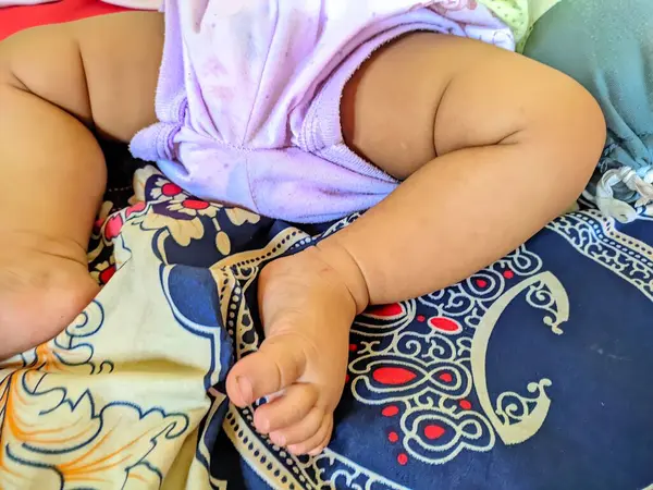 Bebeklerin ayakları desenli kumaş üzerinde, ebeveynlik blogları, çocuk bakımı siteleri, bebek ürünü reklamları ve aile tasarım projeleri için ideal..