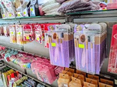 Mor makyaj fırçasının kapağı çeşitli kozmetik ürünlerin yanında bir mağaza rafında güzelce sergileniyor.. 