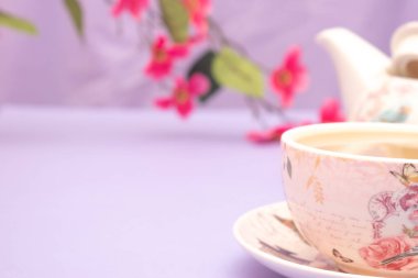 Beyaz arkaplanlı pembe masada çay ya da çay..