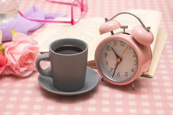 Çalar saat, bardak ve kitaplar.