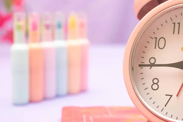 Ahşap bir arka planda pembe çalar saat. Yılın konsepti..